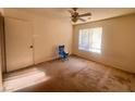 Bedroom featuring a ceiling fan, window and showing worn carpet at 8070 W Russell Rd # 2068, Las Vegas, NV 89113