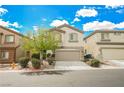 Beige two-story house with attached garage and a tree in the front yard at 9757 Marcelline Ave, Las Vegas, NV 89148