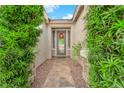 Welcoming front entrance with a decorative wreath and lush green shrubbery at 10125 James Harbin Ave, Las Vegas, NV 89129