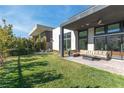 Spacious backyard featuring a manicured lawn, comfortable seating, and modern architecture at 11015 Sanctuary Cove Ct, Las Vegas, NV 89135