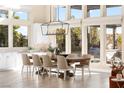 Bright dining area with a farmhouse table, pendant lighting, and large windows at 11015 Sanctuary Cove Ct, Las Vegas, NV 89135
