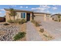 House exterior with walkway leading to front door and two-car garage at 4430 Deliza Ln, Pahrump, NV 89061