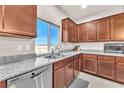 Kitchen features granite counters, wood cabinets, and a double sink at 5878 Iris Vineyards Ave, Las Vegas, NV 89141