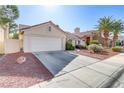 Single-story home showcasing desert landscaping, a two-car garage, and a driveway at 9905 Barrier Reef Dr, Las Vegas, NV 89117