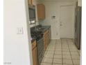 Light wood cabinets, stainless steel appliances, and tile flooring at 10321 Junction Hill Dr, Las Vegas, NV 89134