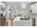 Modern kitchen with white cabinets, marble countertops, and stainless steel appliances at 10729 Grey Havens Ct, Las Vegas, NV 89135