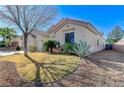 Beautiful view of the side yard featuring desert landscaping and a well manicured lawn at 1595 Cattle Ranch Pl, Henderson, NV 89002