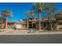 Luxury home with stone exterior, palm trees, and gated entry at 646 Saint Croix St, Henderson, NV 89012