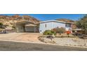 Inviting single-story home features covered parking, xeriscaping, and a mountain view at 648 Mount Blackburn Ln, Boulder City, NV 89005