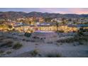 Sprawling estate aerial view at sunset with stunning pool, palm trees, and mountain backdrop at 942 Villa Grande Way, Boulder City, NV 89005