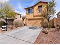 Attractive tan two-story home with a two-car garage and xeriscaped front yard at 1012 Water Cove St, Henderson, NV 89011