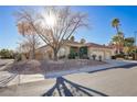 Single-story home with a three-car garage and nicely landscaped yard at 10201 Los Padres Pl, Las Vegas, NV 89134