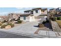 Two-story house with beige exterior, landscaped yard, and a two-car garage at 12 Oro Valley Dr, Henderson, NV 89052