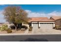 House exterior with gray double garage doors and desert landscaping at 1592 Bamboo Bay Dr, Henderson, NV 89012