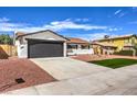 Updated single story home with a dark gray garage door at 1700 Breezewood Dr, Las Vegas, NV 89108