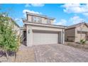 Two story home featuring a two car garage, stone driveway, neutral color, and low maintenance desert landscaping at 2430 Bellinzona Pl, Henderson, NV 89044