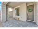 Front porch with a wooden bench and a wreath on the door at 2598 Iron Crest Ln, Las Vegas, NV 89138