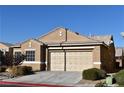 Tan one-story house with a two-car garage and desert landscaping at 304 Whitney Breeze Ave, North Las Vegas, NV 89031