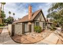 View of the side of the house with a brick chimney and a gate to a backyard at 3988 Salisbury Pl, Las Vegas, NV 89121