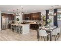 Spacious kitchen with an island, dark cabinets and dining area at 8113 Brown Clay Ave, Las Vegas, NV 89113