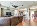 Inviting living room with hardwood floors, ceiling fan, and an open layout with views of the kitchen and dining area at 8396 Waylon Ave, Las Vegas, NV 89178