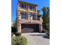 Two story house with a brown door and attached garage at 8428 Summers Ranch Ct, Las Vegas, NV 89139