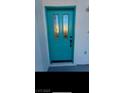 Teal front door with glass panels adds a pop of color to the home's exterior at 8509 Copper Falls Ave, Las Vegas, NV 89129