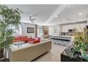 Open-concept living room with modern furnishings, tile flooring, and adjacent kitchen area at 889 Ariel Heights Ave, Las Vegas, NV 89138