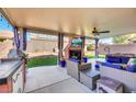 Enjoy the outdoors on this covered patio featuring a fireplace, seating, and outdoor kitchen at 3740 Corte Bella Hills Ave, North Las Vegas, NV 89081