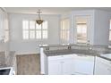 Kitchen with granite countertops, white cabinets, and a breakfast bar at 53 Flowering Desert Dr, Palm Gardens, NV 89039