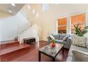 Living room with hardwood floors, gray sofa, and staircase at 7481 Benlomond Ave, Las Vegas, NV 89179