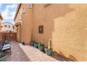 Landscaped side yard with brick pavers and potted plants at 7481 Benlomond Ave, Las Vegas, NV 89179