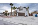 Two-story house with brown garage door and palm trees at 881 Stonehenge St, Las Vegas, NV 89110