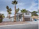 Two-story house with brown garage door and palm trees at 881 Stonehenge St, Las Vegas, NV 89110