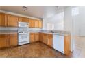 Kitchen with light wood cabinets, white appliances, and tile floor at 10441 Concetta Ave, Las Vegas, NV 89129