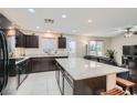 Modern kitchen with granite counters, dark cabinets, and an island at 10548 Seasonable Dr, Las Vegas, NV 89129