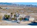 Large house on a spacious lot with palm trees and mountain backdrop at 1411 E Blosser Ranch Rd, Pahrump, NV 89060