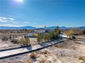 House with a long driveway, landscaping and mountain views in the background at 1411 E Blosser Ranch Rd, Pahrump, NV 89060