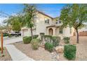 Two-story house with beige exterior, three-car garage, and landscaping at 221 Raptors View Ave, North Las Vegas, NV 89031