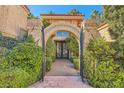 Elegant entryway with stone archway and wrought iron gate leading to front door at 24 Wild Dunes Ct, Las Vegas, NV 89113