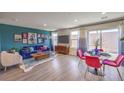 Bright and airy living area with dining space, a blue sofa and red chairs at 2558 Petunia Garden Ave # 217, North Las Vegas, NV 89081