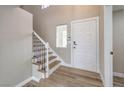 Bright entryway with hardwood floors, staircase, and white door at 275 Adorno Dr, Henderson, NV 89074