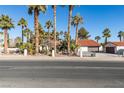 Single story home with multiple palm trees and gated entrance at 3990 Melody Ln, Las Vegas, NV 89108