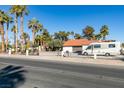 House with RV parking, mature palm trees, and a gated entrance at 3990 Melody Ln, Las Vegas, NV 89108