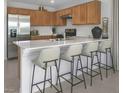 Modern kitchen with light wood cabinets, stainless steel appliances, and an island with seating at 4199 Nopal Serrano Ave, Las Vegas, NV 89141