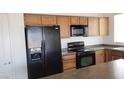 Kitchen with oak cabinets, black appliances, and granite countertops at 4290 S Gressa St, Pahrump, NV 89061