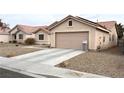 Tan house with a two-car garage and gravel driveway at 4618 Zia Ridge St, North Las Vegas, NV 89031