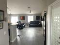 Open concept living room with wood-look floors, neutral walls, ceiling fan, and sliding glass door at 4618 Zia Ridge St, North Las Vegas, NV 89031