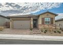 Single-story home with a two-car garage and landscaped front yard at 473 Harvest Rain Ave, Henderson, NV 89011