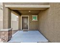 Covered entryway with a brick accent and a modern door at 521 Abrazar Ave, North Las Vegas, NV 89081